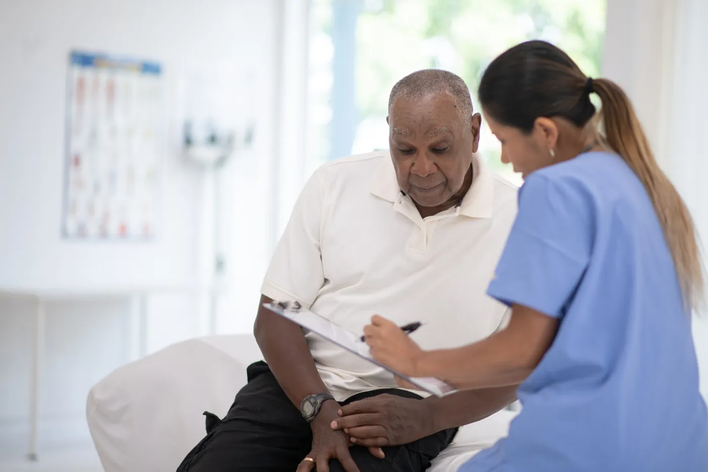 A nurse reviewing treatment with an older male patient
